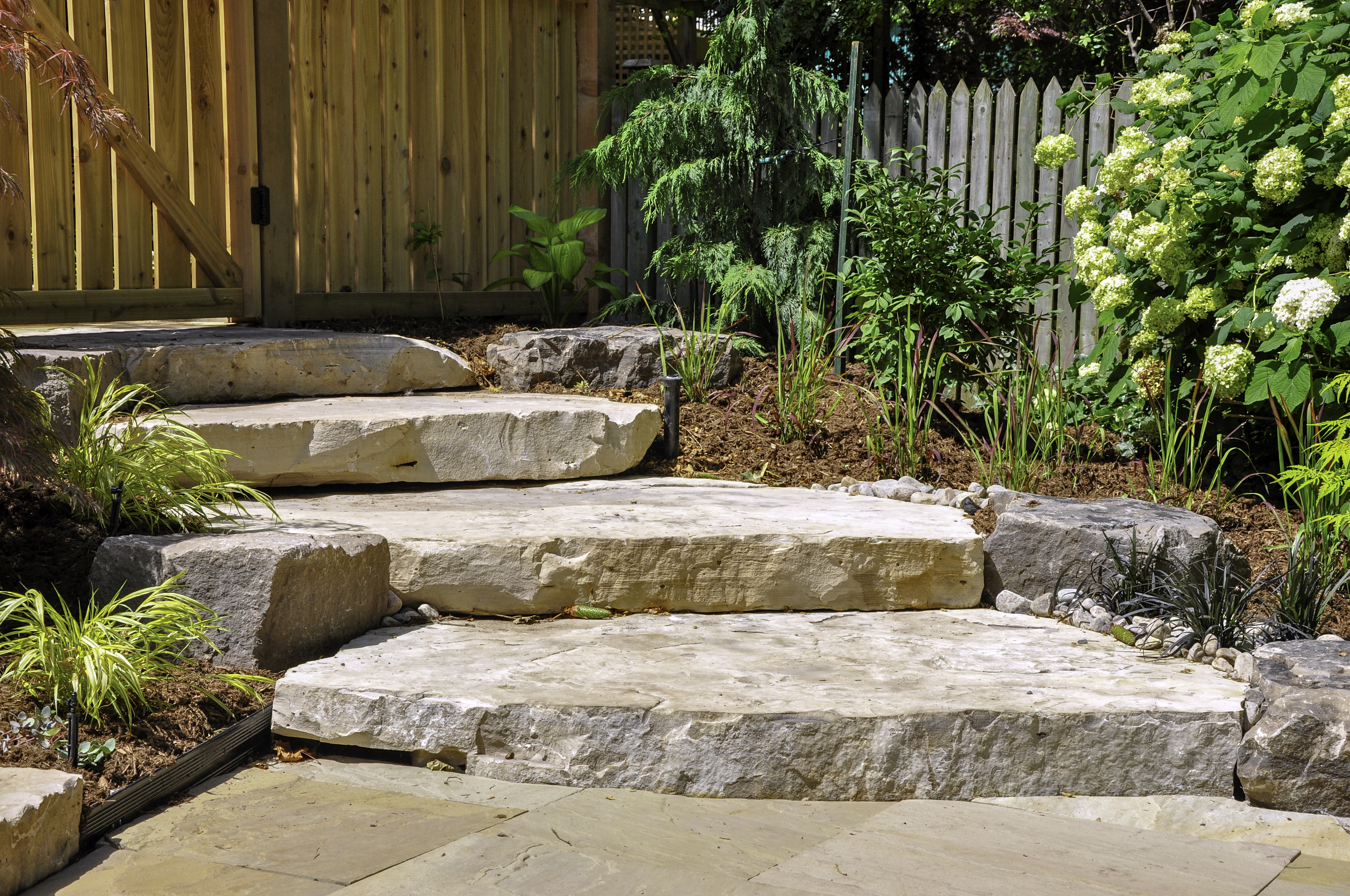 Huge natural stone slab steps create a beautiful urban front gar